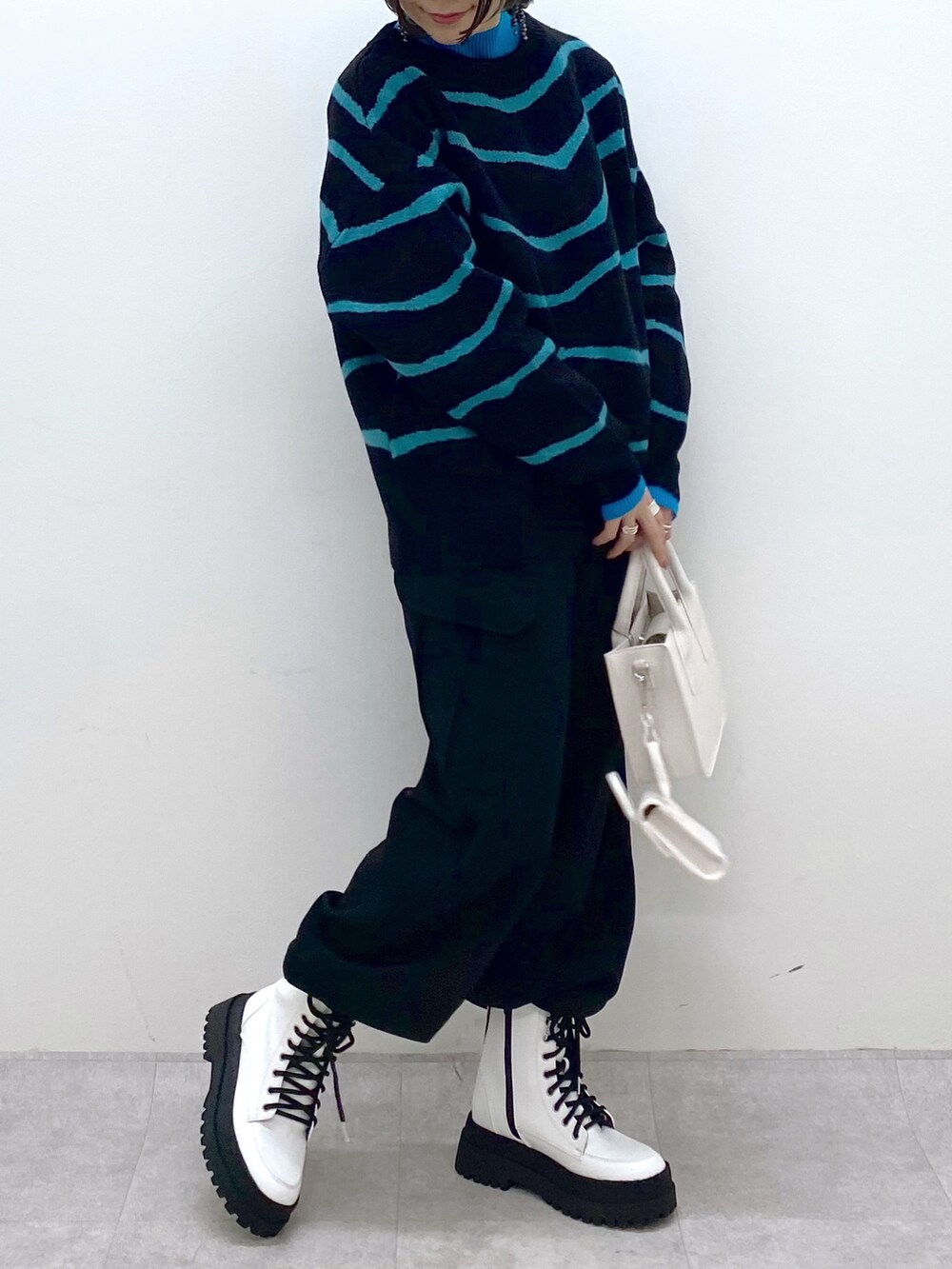 ブラック系のトップス、ブラック系のカーゴパンツ、ホワイト系のバッグを着用したレディースの秋コーディネートの4枚目の写真