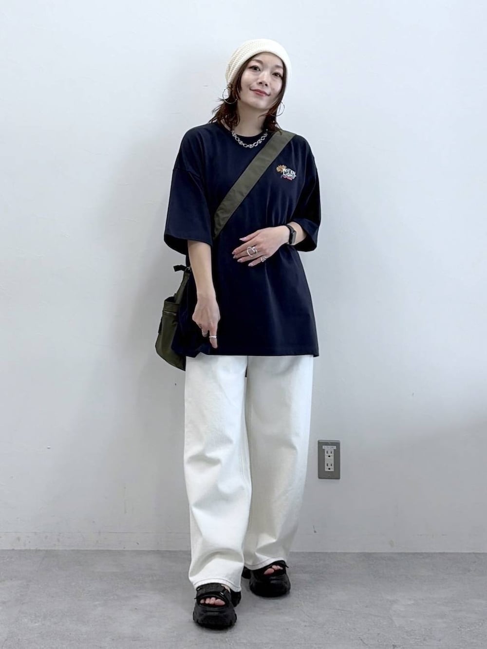 グリーン系のボストンバッグ、ホワイト系のスラックス、ブルー系のTシャツ/カットソーを着用したレディースの春コーディネートの4枚目の写真