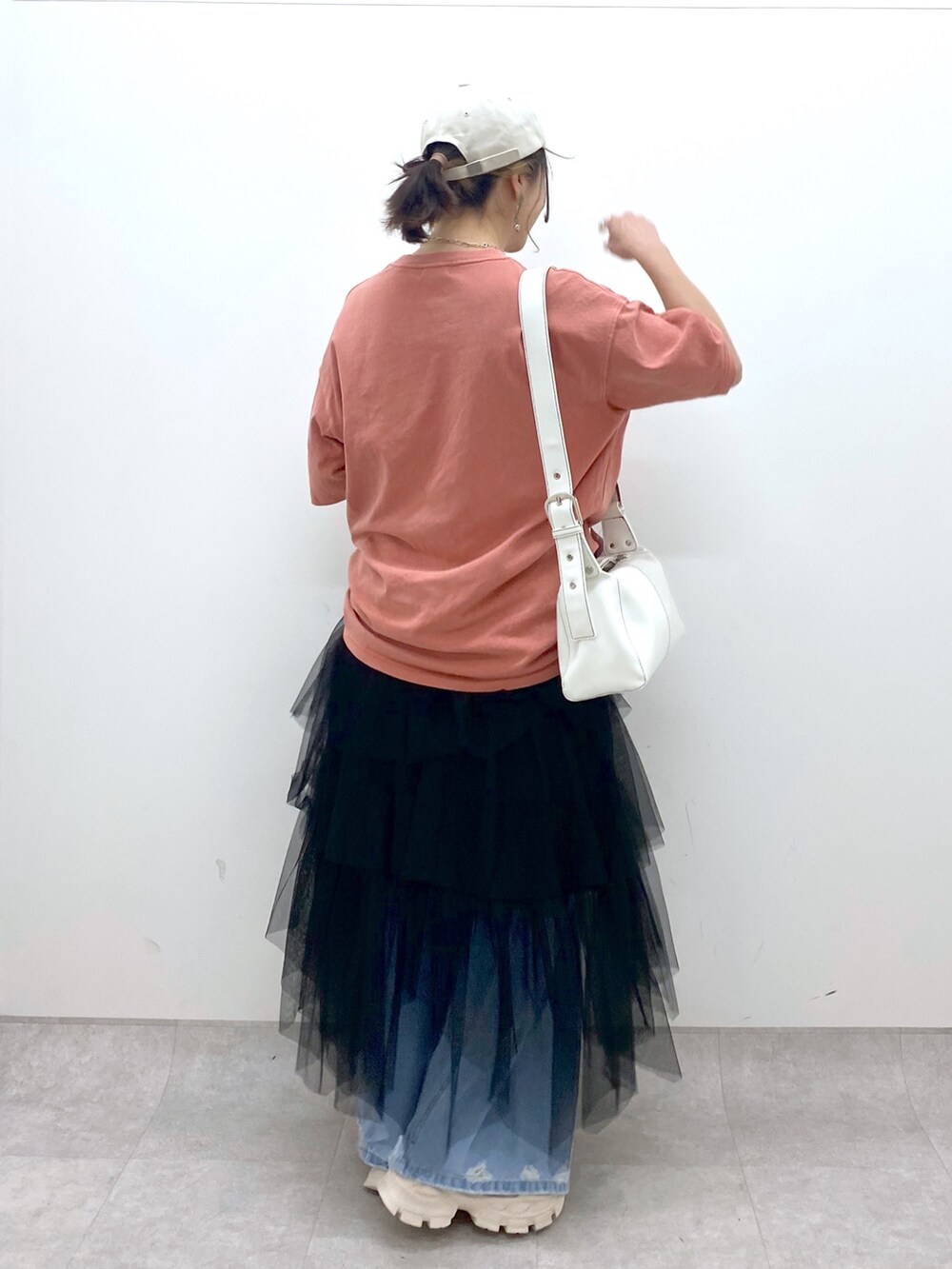 ブルー系のデニムパンツ、オレンジ系のTシャツ/カットソー、ブラック系のスカートを着用したレディースの夏コーディネートの3枚目の写真