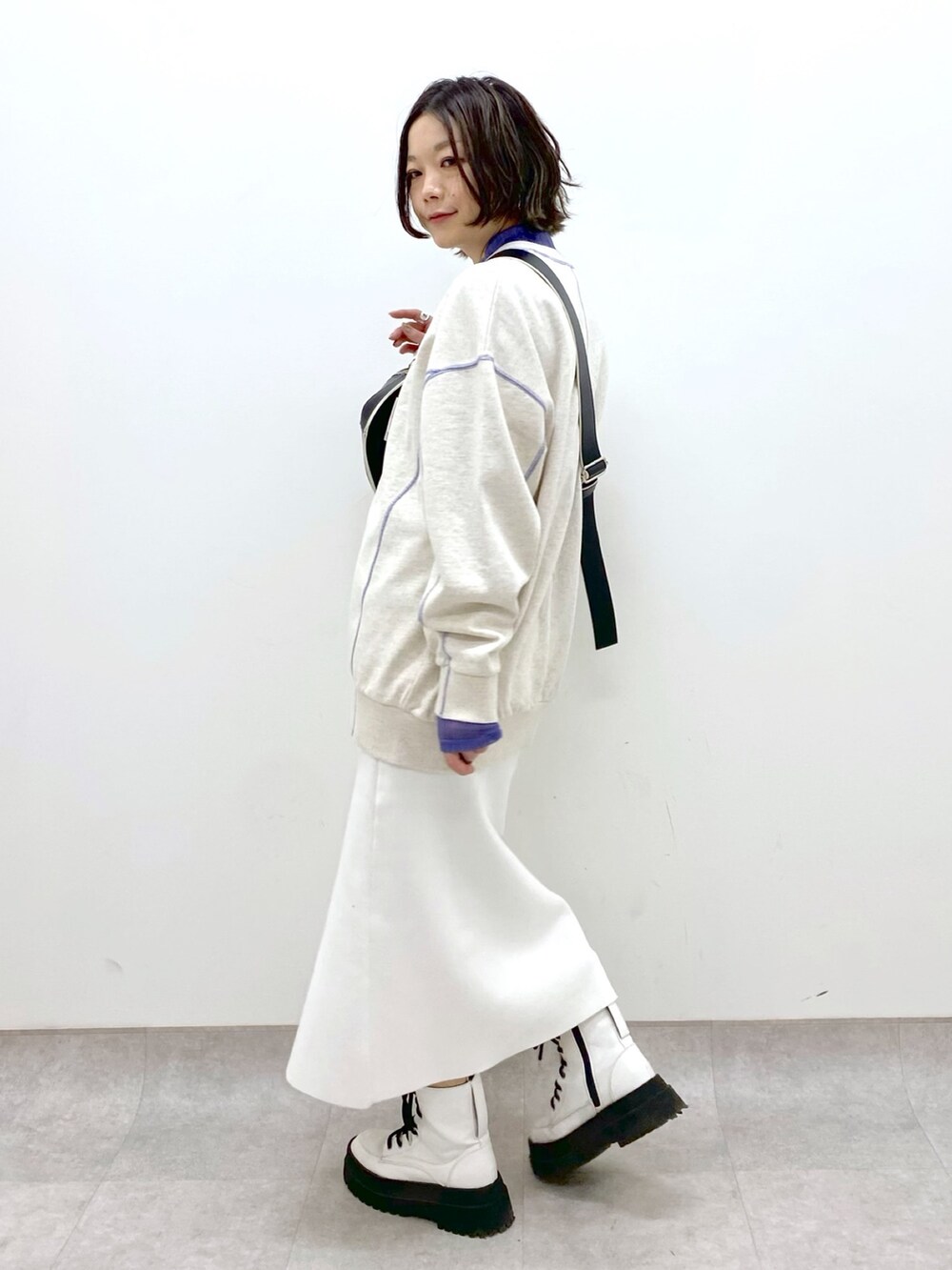 ホワイト系のスカート、ベージュ系のトップス、パープル系のトップスを着用したレディースの春コーディネートの3枚目の写真