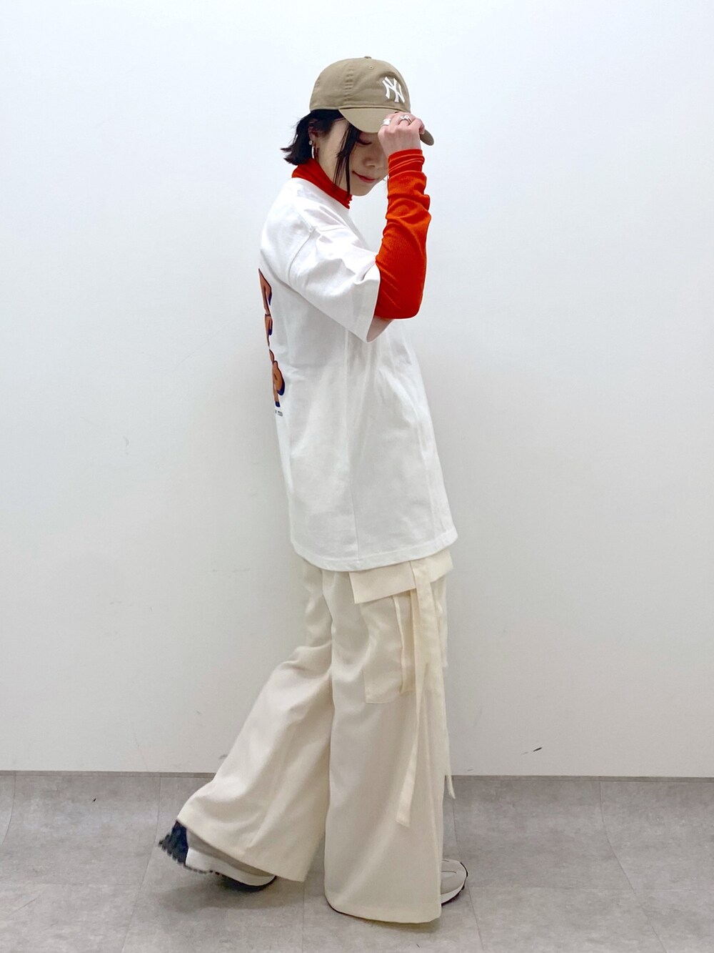 ホワイト系のトップス、ホワイト系のパンツ、ベージュ系のスニーカーを着用したレディースの春コーディネートの3枚目の写真