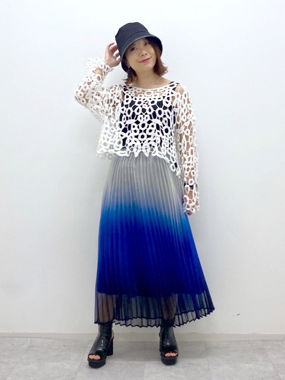 ブルー系のスカート、ブラック系のタンクトップ、ブラック系のサンダルを着用したレディースの春コーディネートの2枚目の写真