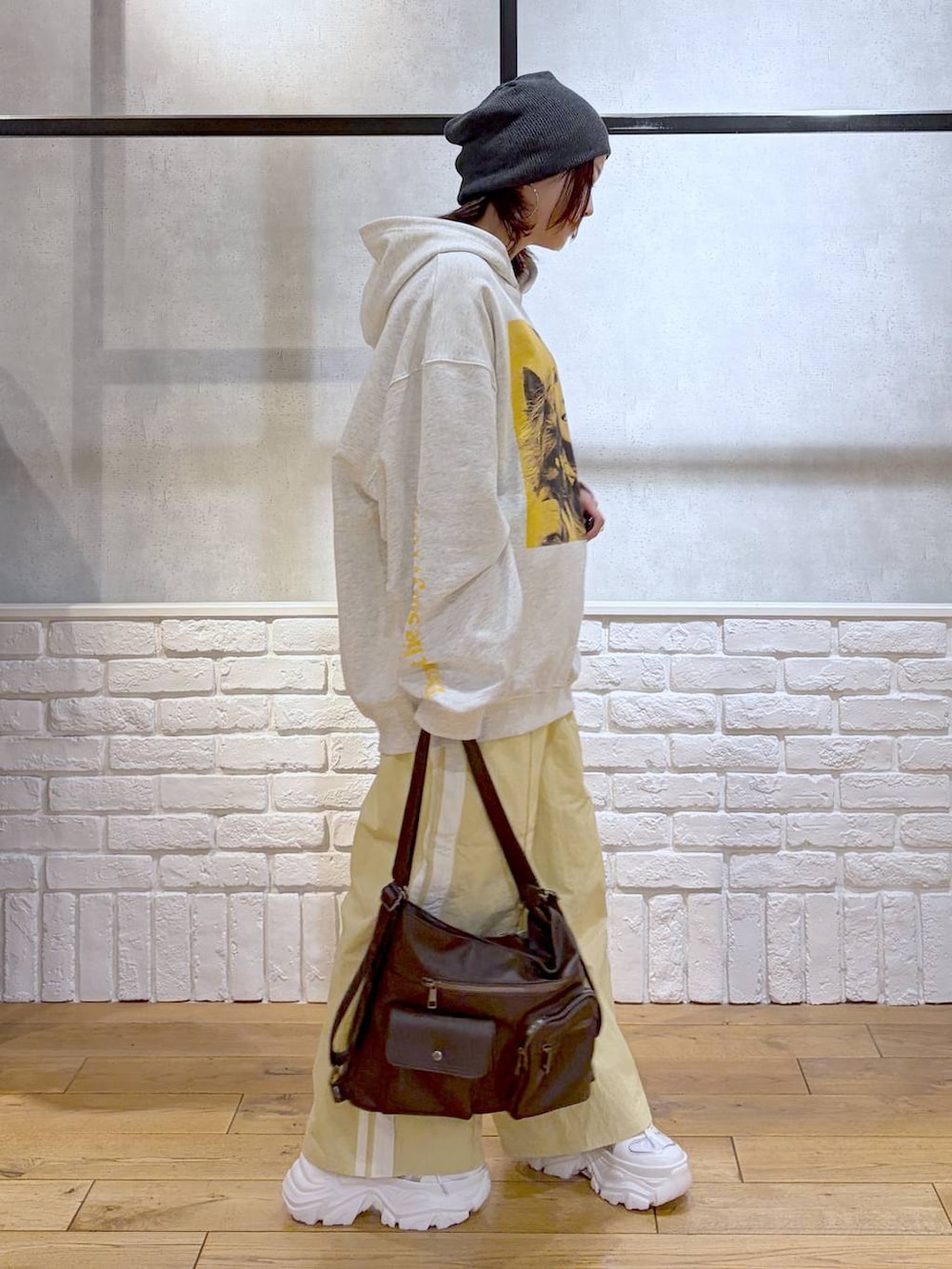 ホワイト系のスニーカー、イエロー系のスウェットパンツ、ブラウン系のショルダーバッグを着用したレディースの春コーディネートの7枚目の写真