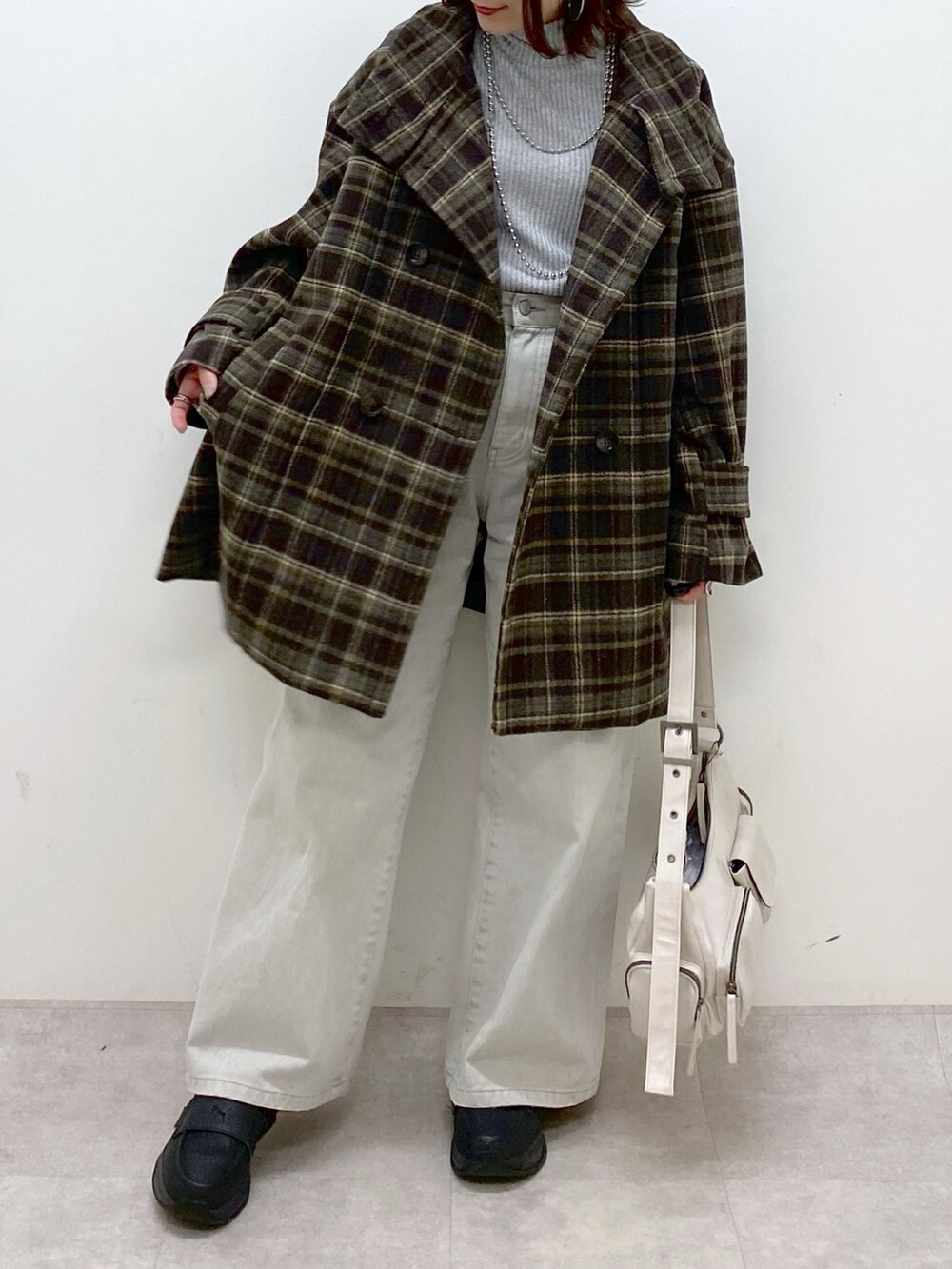 ブラウン系のテーラードジャケット、グレー系のデニムパンツ、ホワイト系のショルダーバッグを着用したレディースの冬コーディネートの3枚目の写真