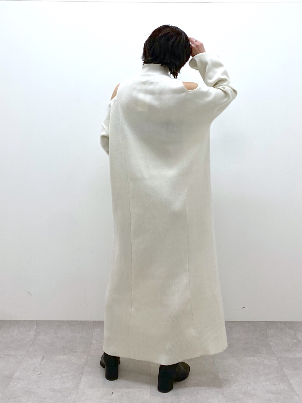 ホワイト系のワンピース、ホワイト系のボディバッグ/ウエストポーチ、ブラック系のTシャツ/カットソーを着用したレディースの冬コーディネートの4枚目の写真