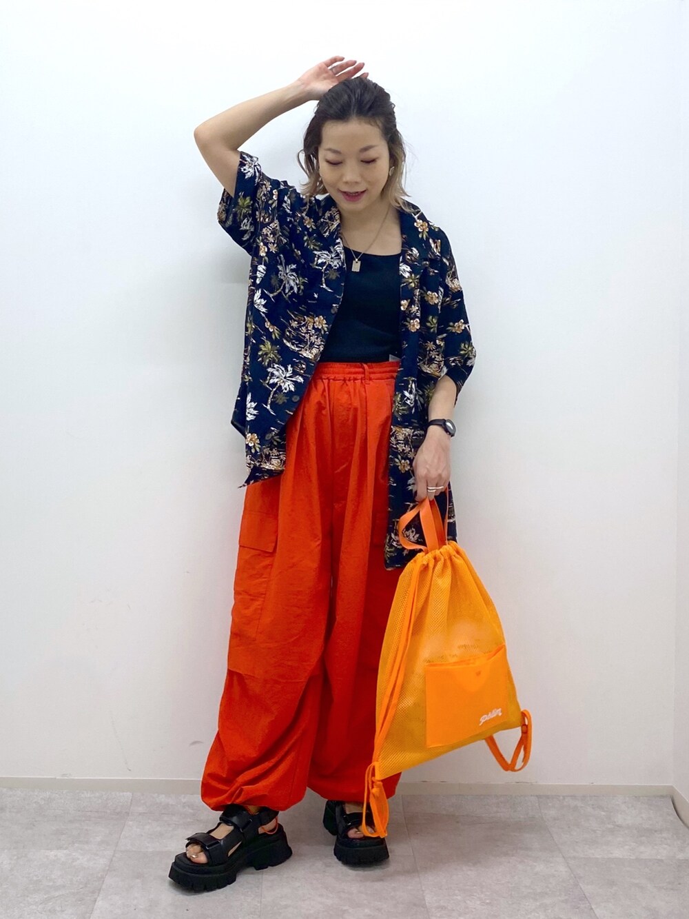 オレンジ系のその他パンツ、ブラック系のサンダル、ブラック系のシャツ/ブラウスを着用したレディースの夏コーディネートの2枚目の写真