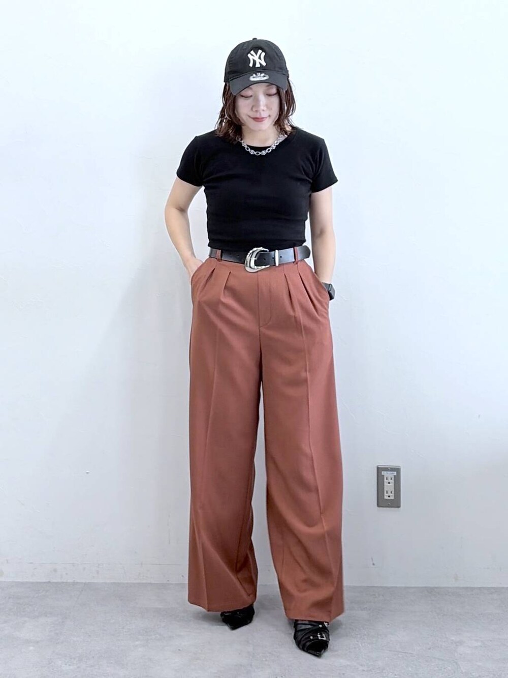 ブラウン系のスラックス、ブラック系のTシャツ/カットソー、ブラック系のキャップを着用したレディースの春コーディネートの8枚目の写真