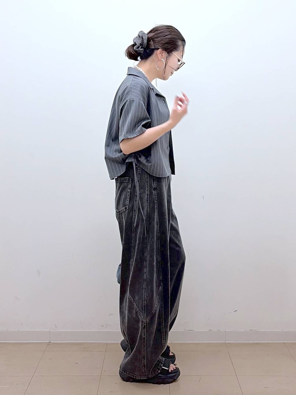 ブラック系のデニムパンツ、ブラック系のサンダル、グレー系のシャツ/ブラウスを着用したレディースの夏コーディネートの7枚目の写真