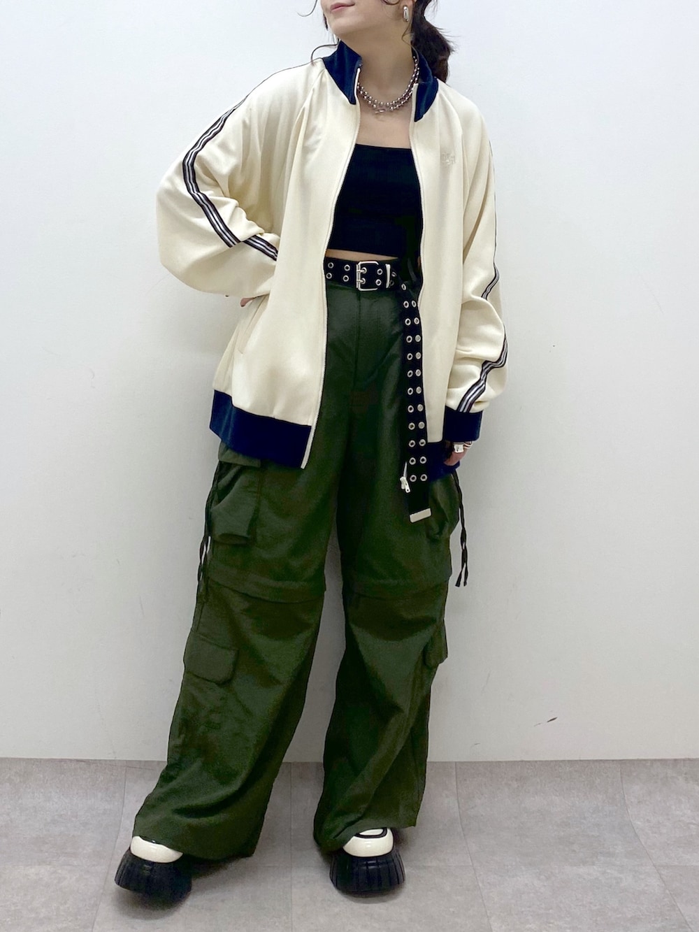 ブラック系のキャミソール、ホワイト系のセットアップ、グリーン系のカーゴパンツを着用したレディースの冬コーディネートの3枚目の写真