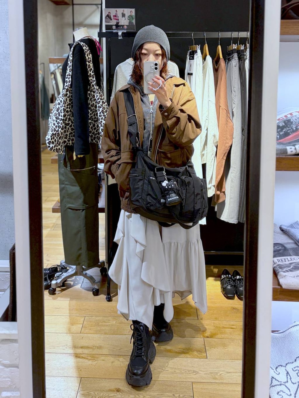 ブラック系のブーツ、ブラック系のボストンバッグ、ブラウン系のブルゾンを着用したレディースの冬コーディネートの2枚目の写真