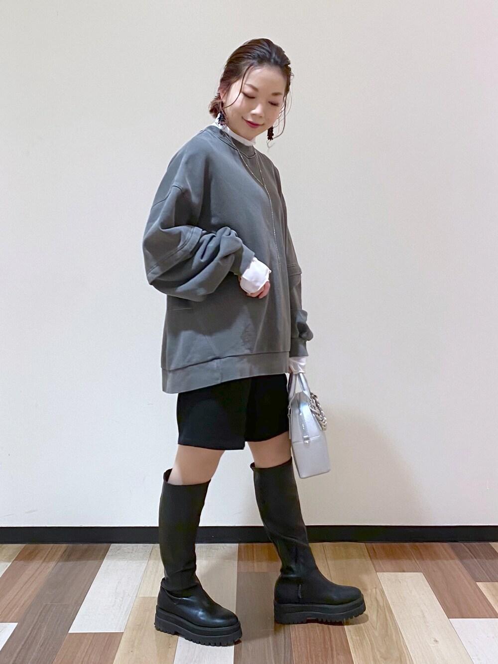 シルバー系のショルダーバッグ、ブラック系のブーツ、ブラック系のその他パンツを着用したレディースの冬コーディネートの3枚目の写真