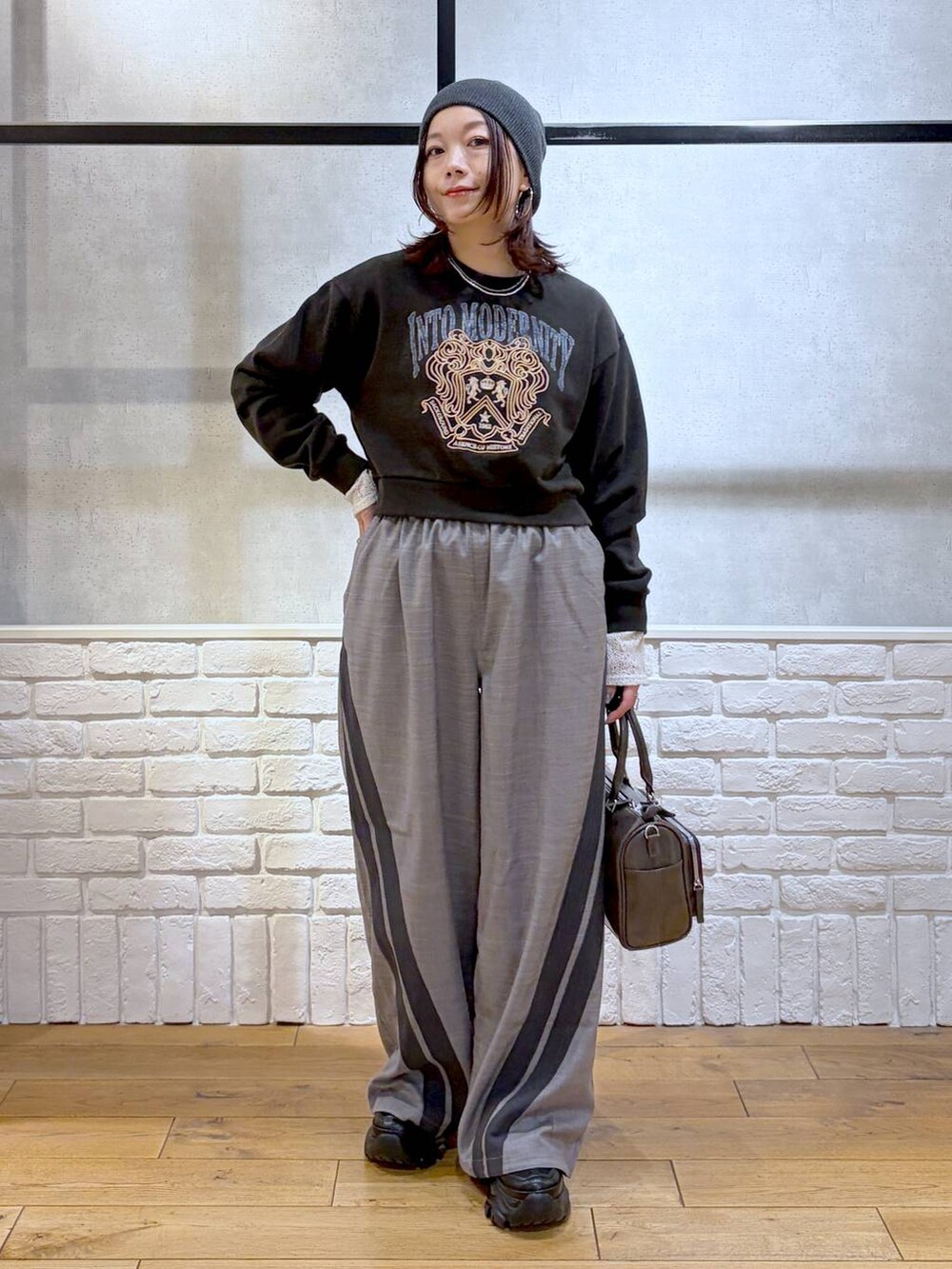 ブラック系のスニーカー、グレー系のスウェット、ブラック系のショルダーバッグを着用したレディースの冬コーディネートの9枚目の写真