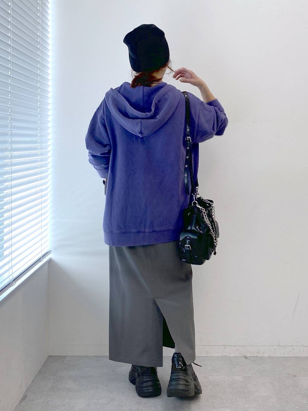 ブラック系のスニーカー、グレー系のスカート、ブラック系のショルダーバッグを着用したレディースの秋コーディネートの5枚目の写真