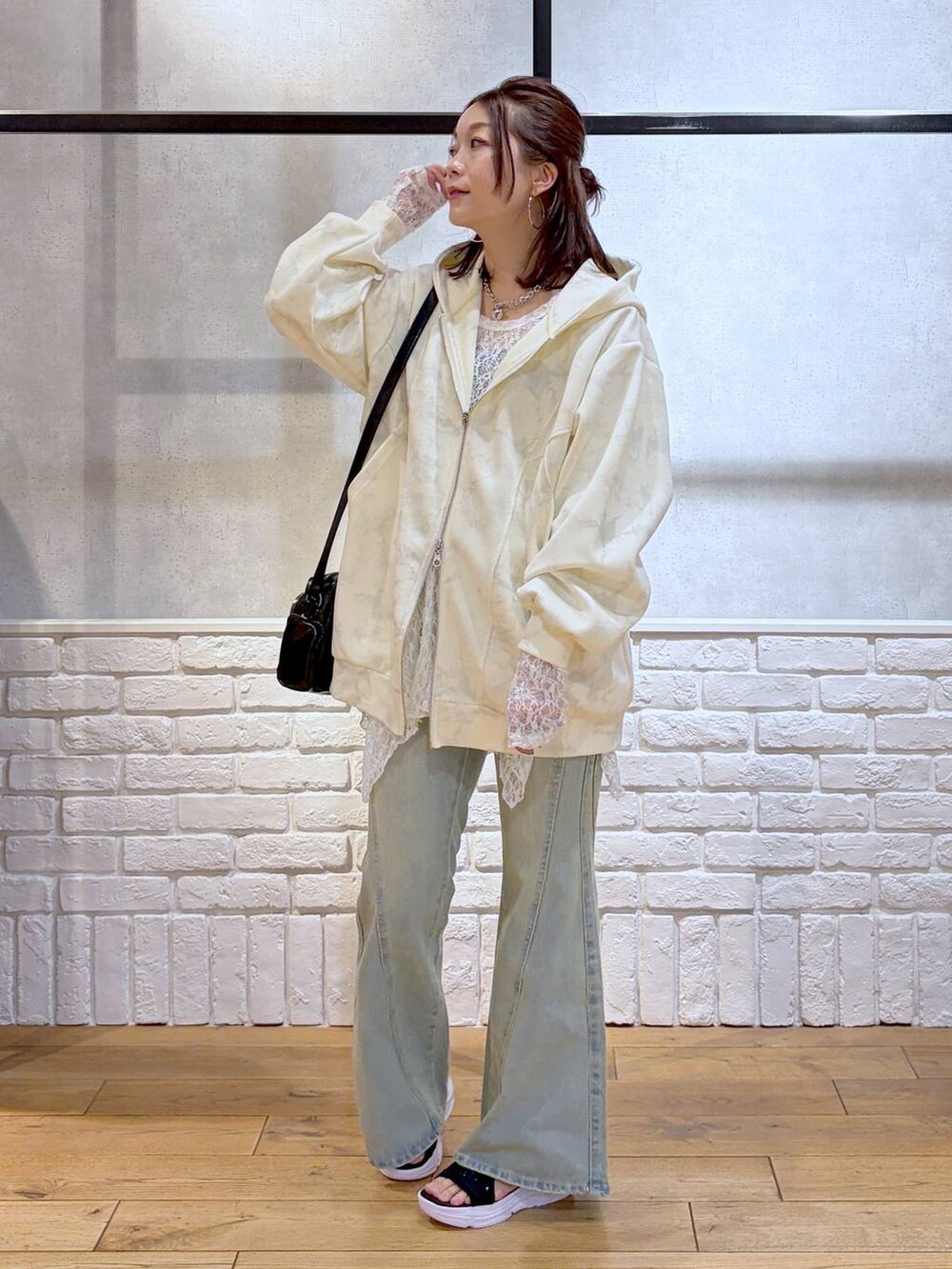 ブルー系のデニムパンツ、ホワイト系のパーカー、ホワイト系のチュニックを着用したレディースの春コーディネートの5枚目の写真