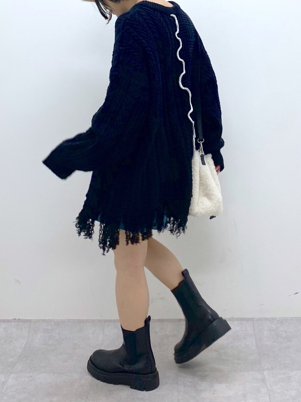 ブラック系のトップス、ブルー系のその他パンツ、ホワイト系のバッグを着用したレディースの秋コーディネートの4枚目の写真