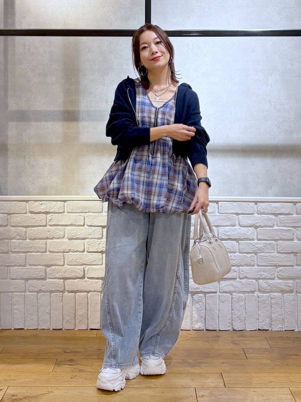 ホワイト系のスニーカー、ホワイト系のボストンバッグ、ブルー系のパーカーを着用したレディースの春コーディネートの4枚目の写真