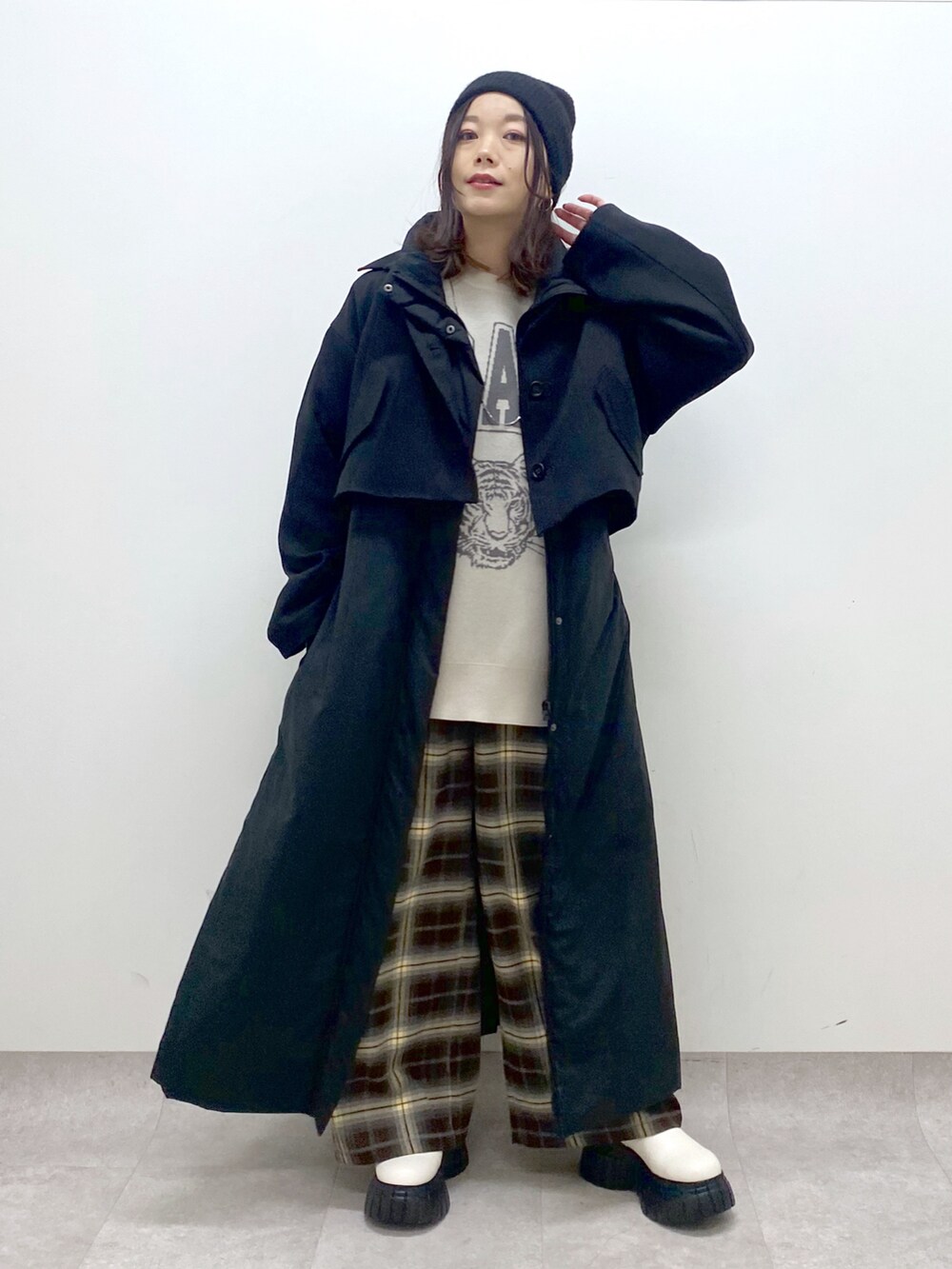 ブラック系のベスト、ベージュ系のニット/セーター、ブラウン系のその他パンツを着用したレディースの秋コーディネートの2枚目の写真