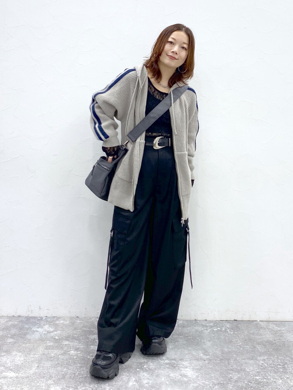 グレー系のニット/セーター、ブラック系のTシャツ/カットソー、ブラック系のスラックスを着用したレディースの秋コーディネートの4枚目の写真