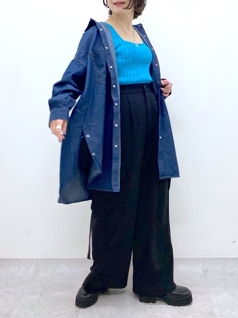 ブラック系のパンツ、ブルー系のトップス、その他のトップスを着用したレディースの春コーディネートの5枚目の写真