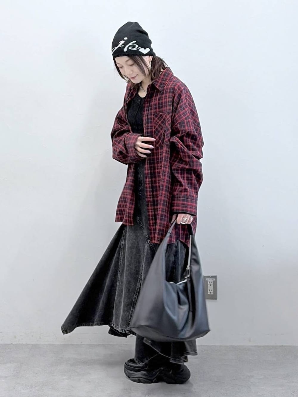 ブラック系のスニーカー、ブラック系のデニムスカート、ブラック系のトートバッグを着用したレディースの春コーディネートの5枚目の写真