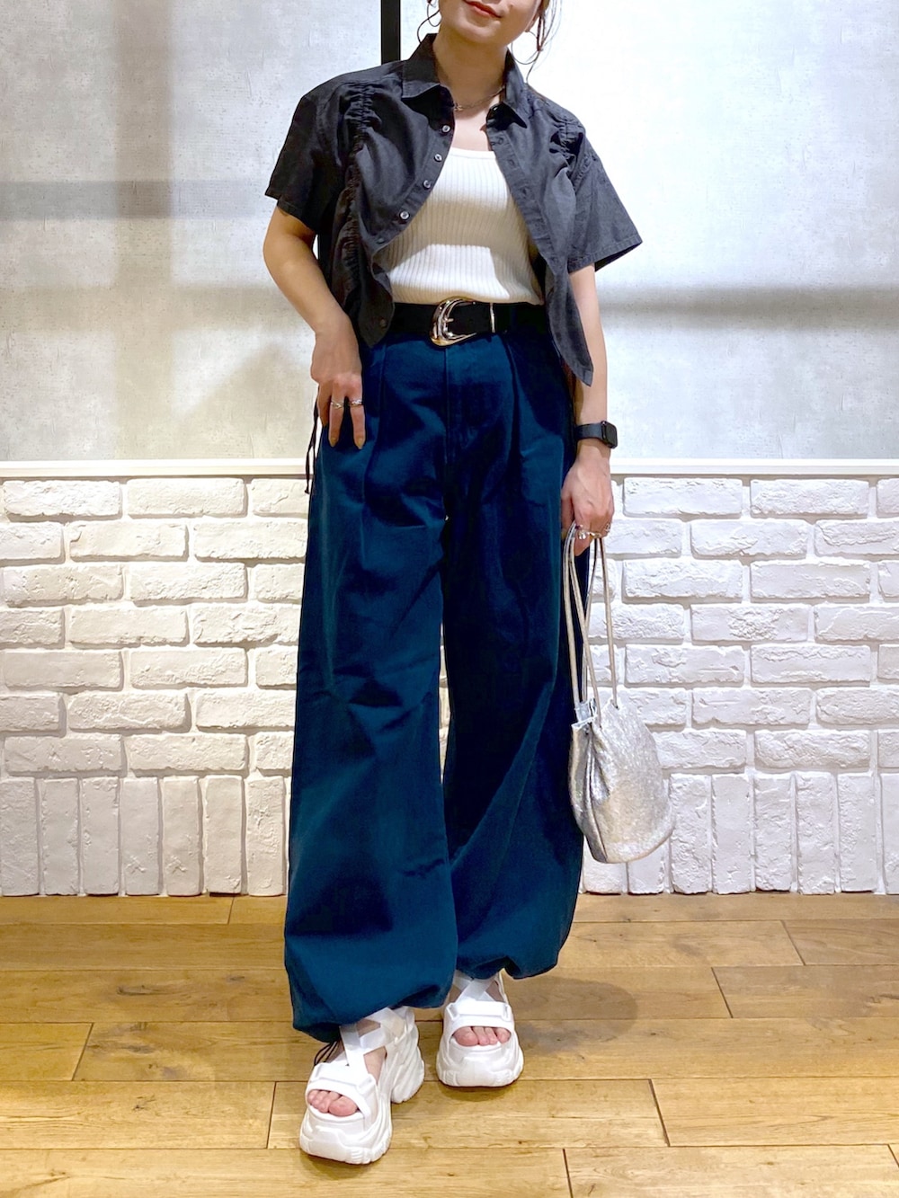 ホワイト系のタンクトップ、ブルー系のチノパンツ、ホワイト系のサンダルを着用したレディースの春コーディネートの3枚目の写真