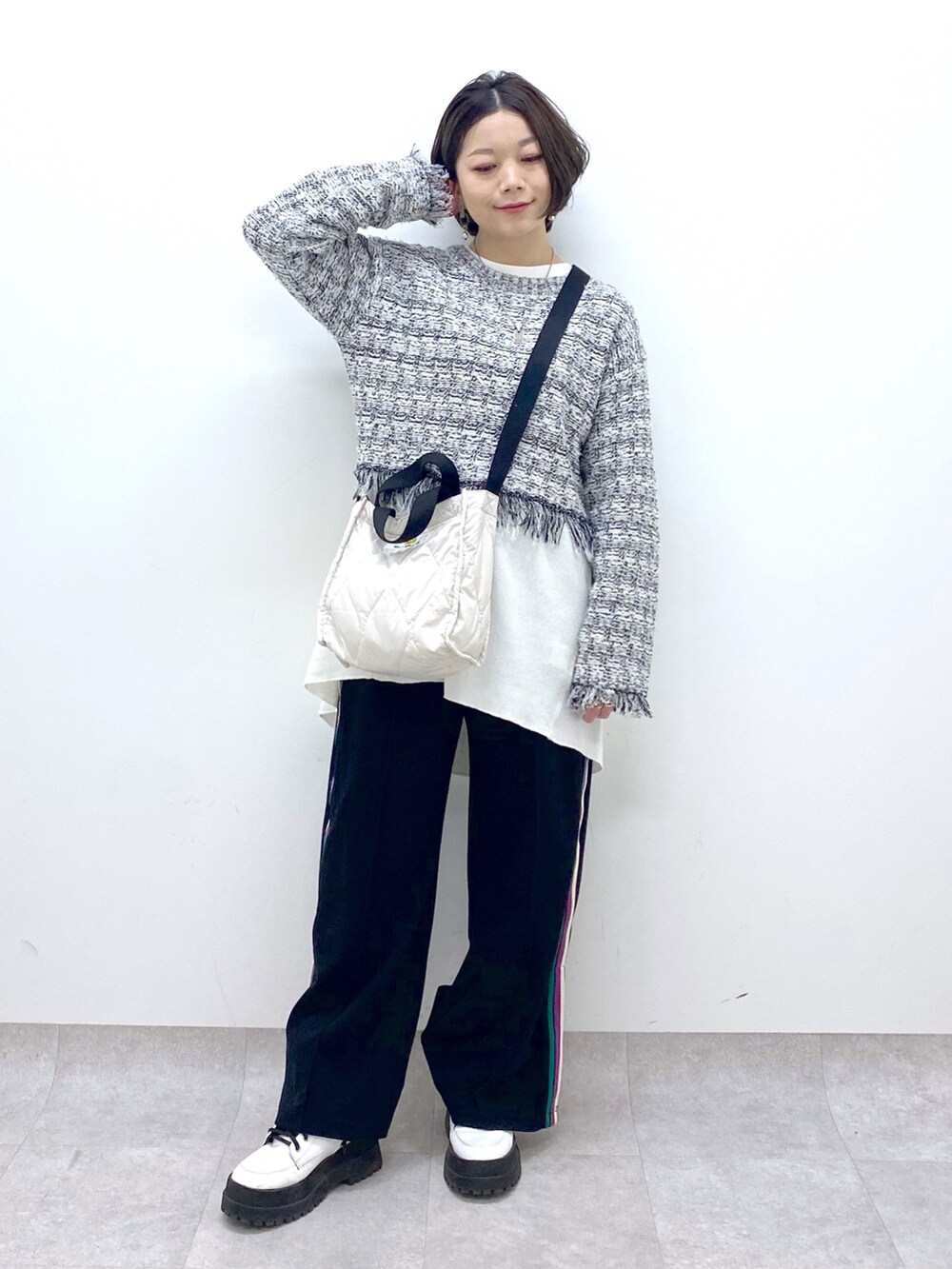 ホワイト系のニット/セーター、ブラック系のスウェットパンツ、ホワイト系のシューズを着用したレディースの春コーディネートの2枚目の写真