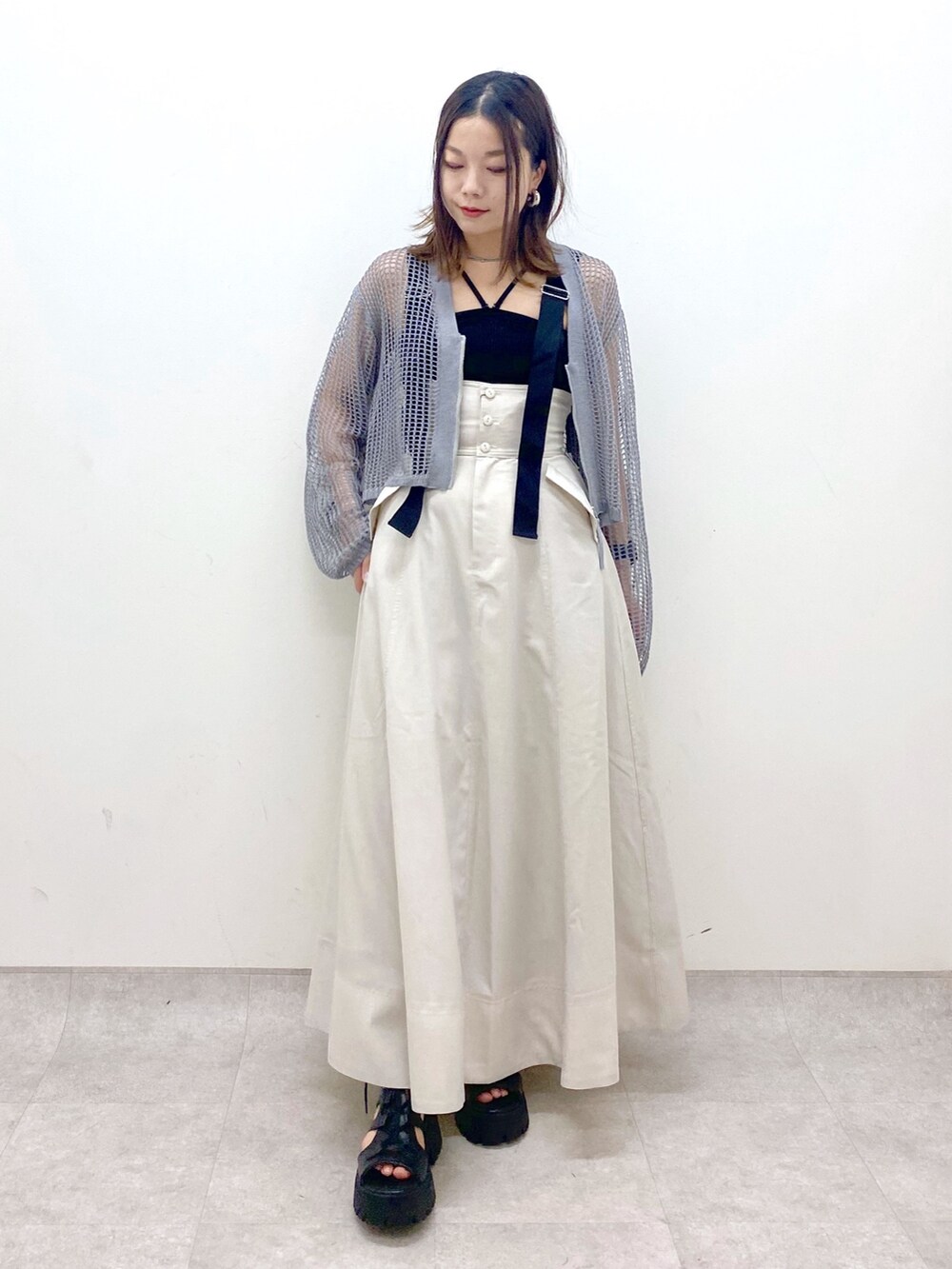 ブラック系のキャミソール、グレー系のカーディガン/ボレロ、ベージュ系のスカートを着用したレディースの春コーディネートの4枚目の写真