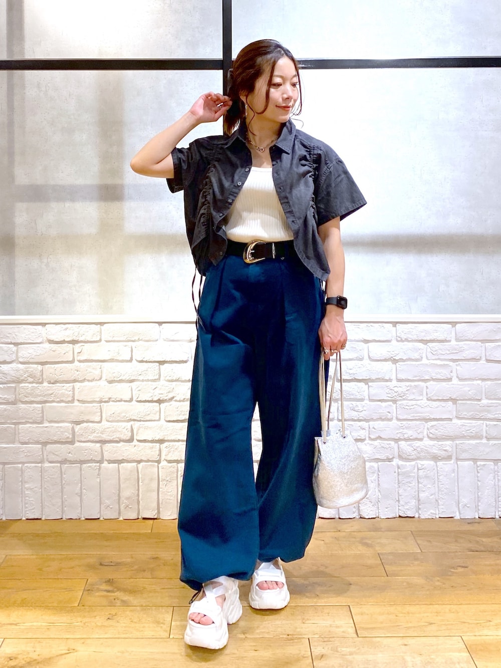 ホワイト系のタンクトップ、ブルー系のチノパンツ、ホワイト系のサンダルを着用したレディースの春コーディネートの4枚目の写真