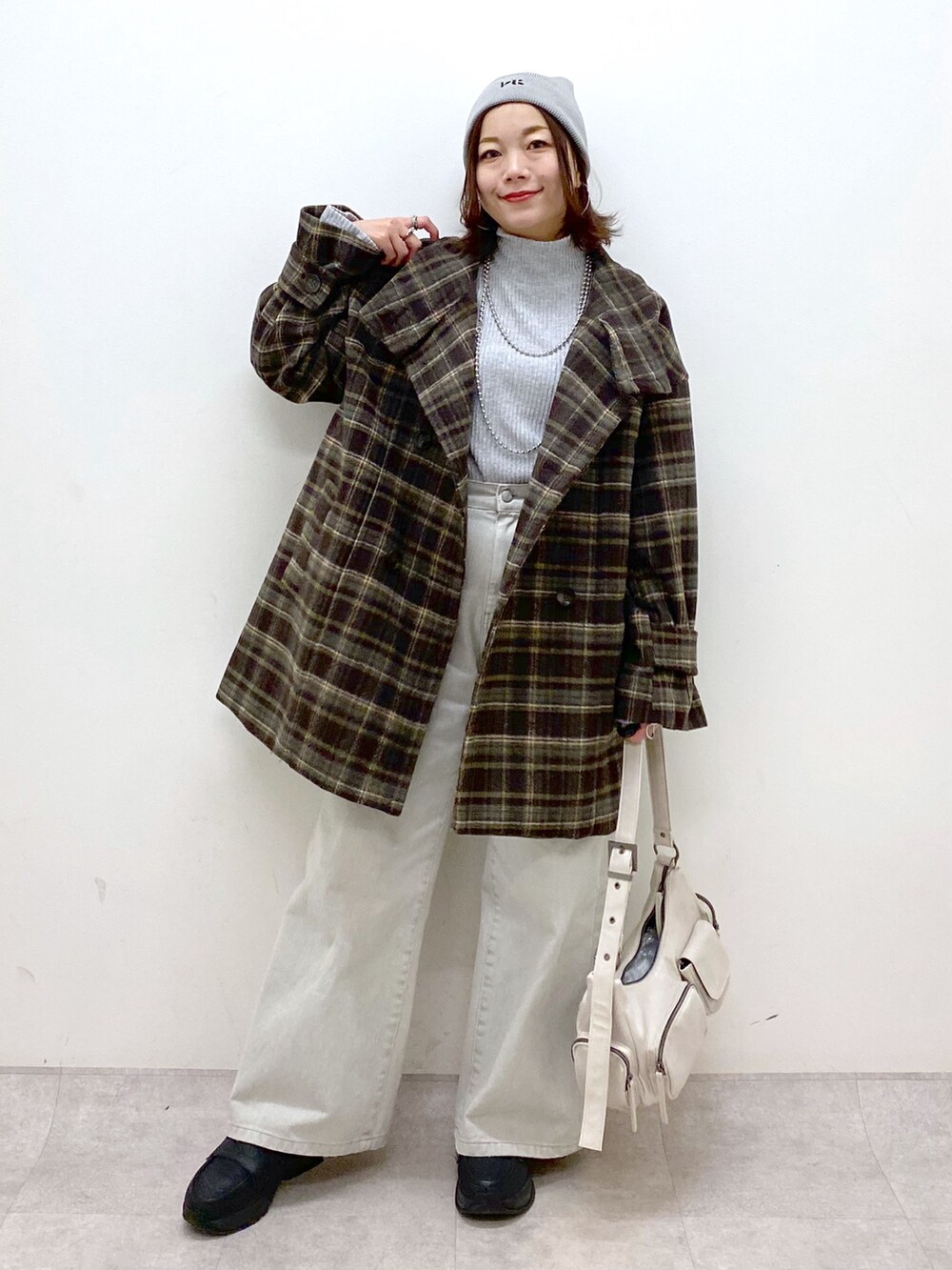ブラウン系のテーラードジャケット、グレー系のデニムパンツ、ホワイト系のショルダーバッグを着用したレディースの冬コーディネートの4枚目の写真