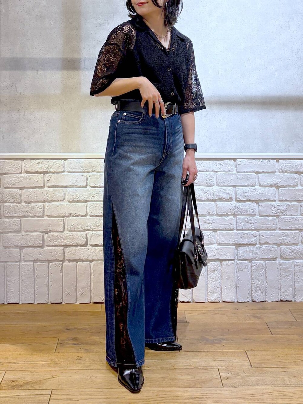 ブルー系のデニムパンツ、ブラック系のシャツ/ブラウス、ブラック系のショルダーバッグを着用したレディースの夏コーディネートの3枚目の写真