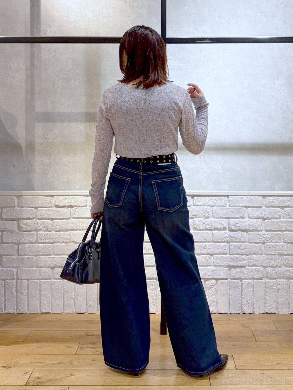 ブルー系のスラックス、ブルー系のハンドバッグ、ブルー系のタンクトップを着用したレディースの春コーディネートの6枚目の写真