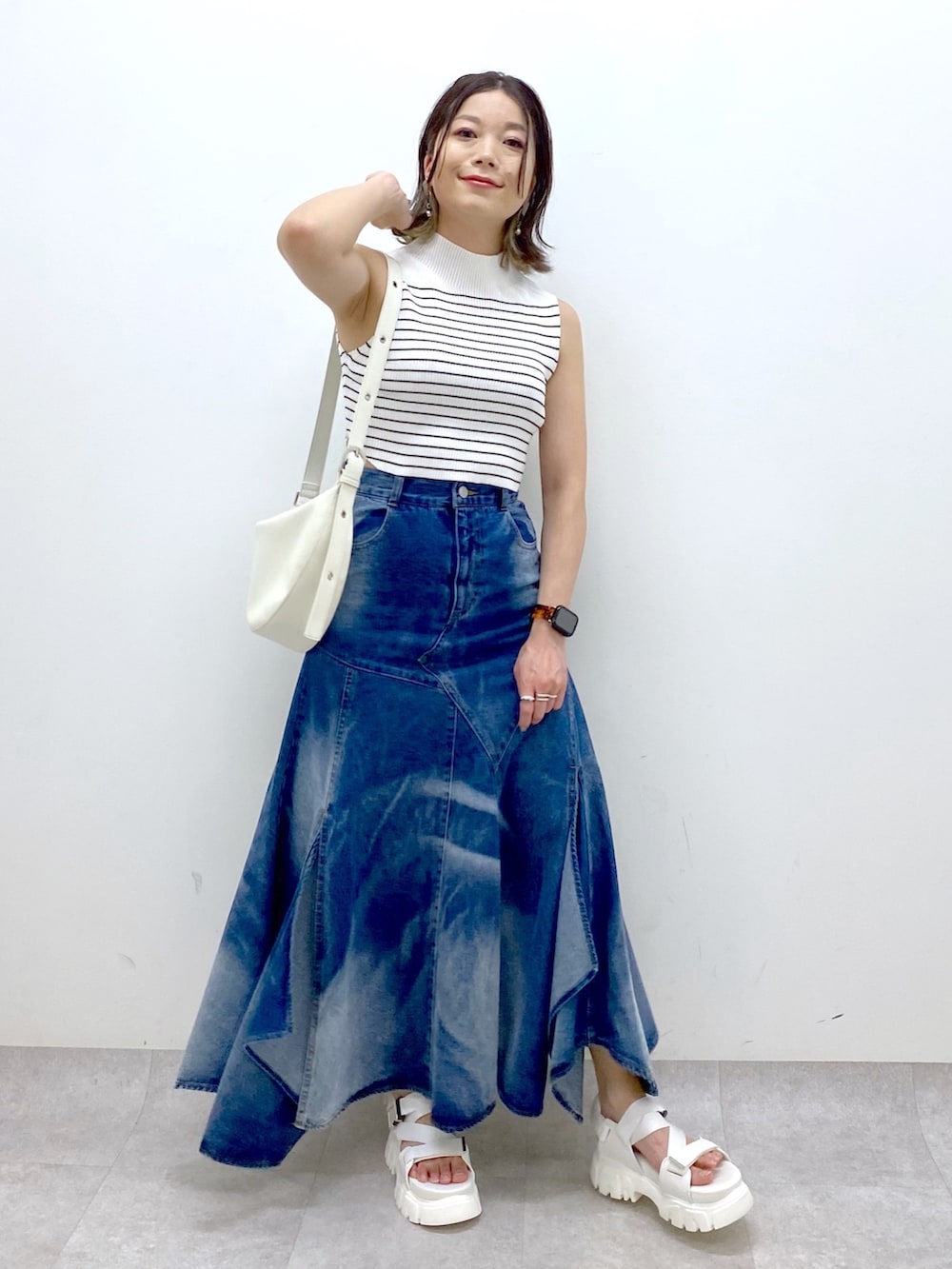 ホワイト系のショルダーバッグ、ブルー系のスカート、ホワイト系のTシャツ/カットソーを着用したレディースの夏コーディネートの8枚目の写真