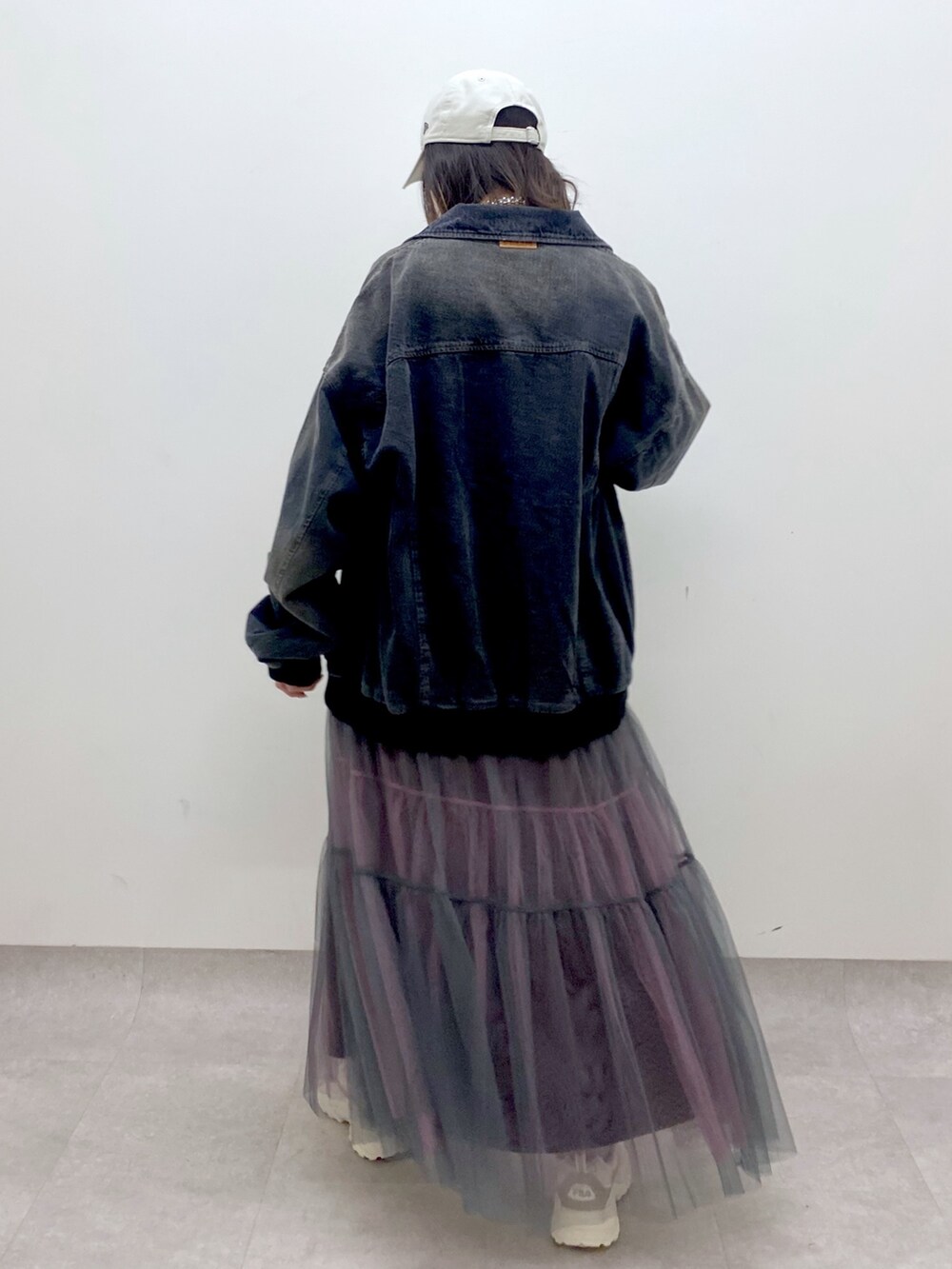 ホワイト系のTシャツ/カットソー、ブラック系のデニムジャケット、グレー系のスカートを着用したレディースの冬コーディネートの6枚目の写真