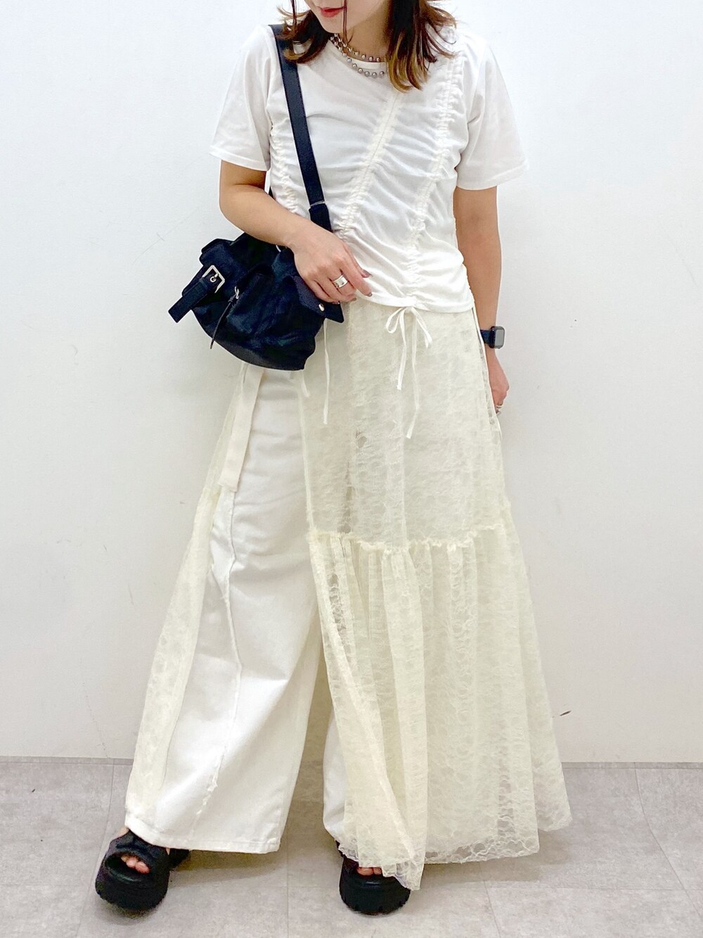 ホワイト系のTシャツ/カットソー、ブラック系のサンダル、ホワイト系のデニムパンツを着用したレディースの春コーディネートの3枚目の写真