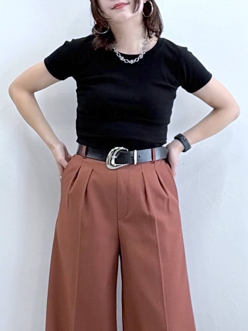 ブラウン系のスラックス、ブラック系のTシャツ/カットソー、ブラック系のキャップを着用したレディースの春コーディネートの2枚目の写真