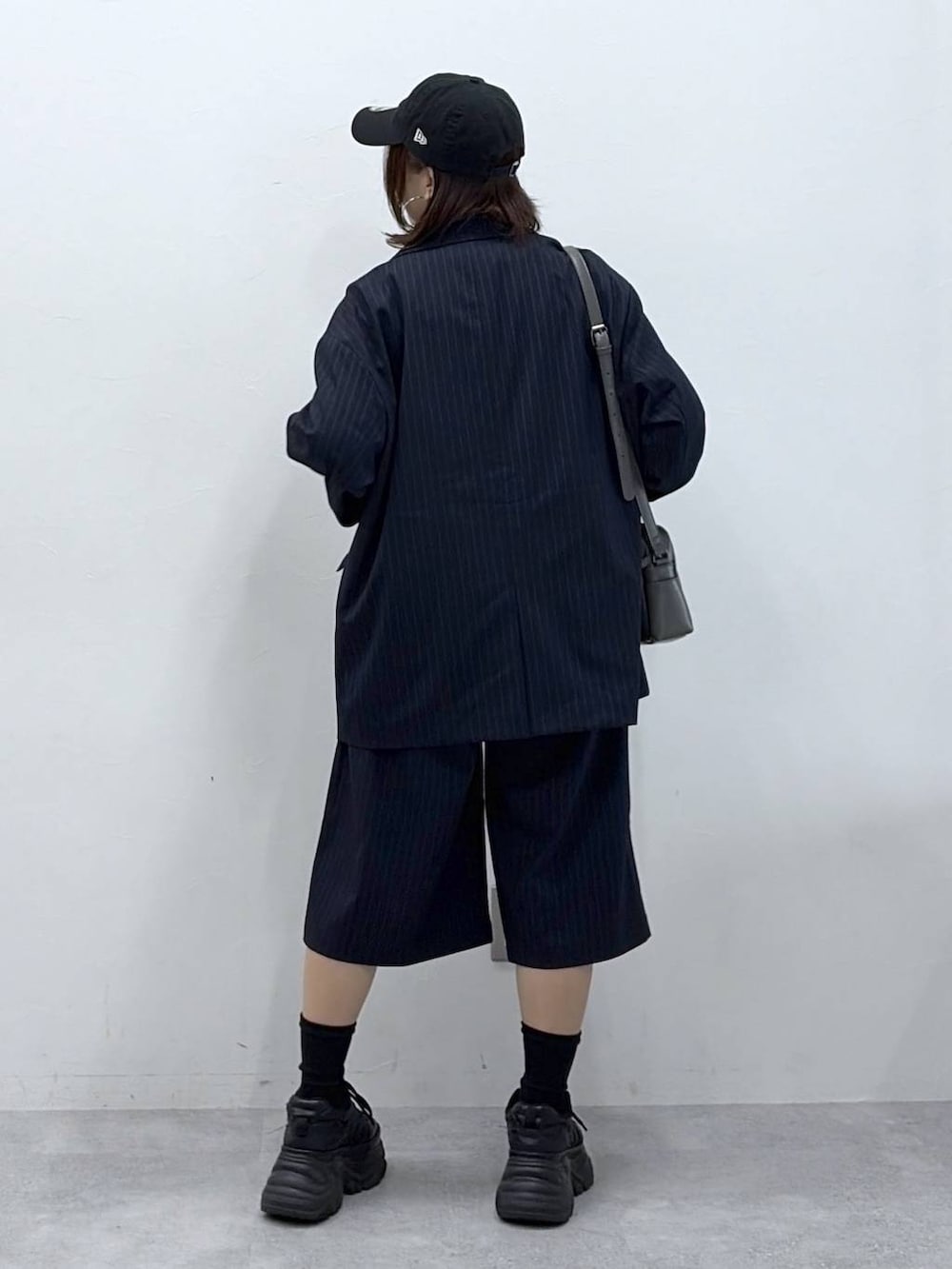 ブラック系のスニーカー、グレー系のショルダーバッグ、ブラック系のTシャツ/カットソーを着用したレディースの春コーディネートの6枚目の写真