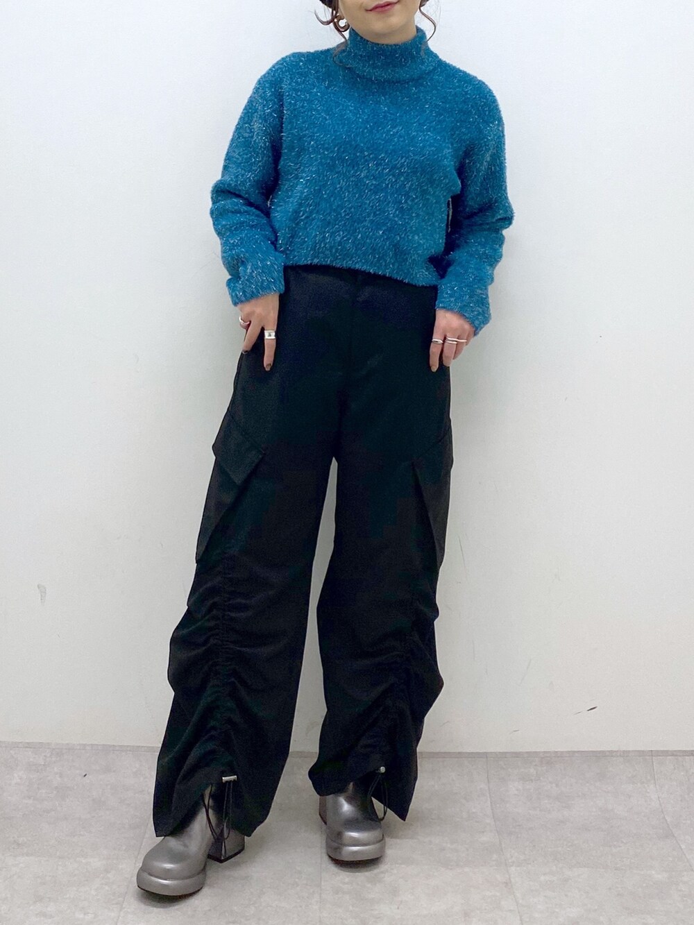 ブルー系のニット/セーター、ブラック系のその他パンツ、その他のブーツを着用したレディースの冬コーディネートの3枚目の写真