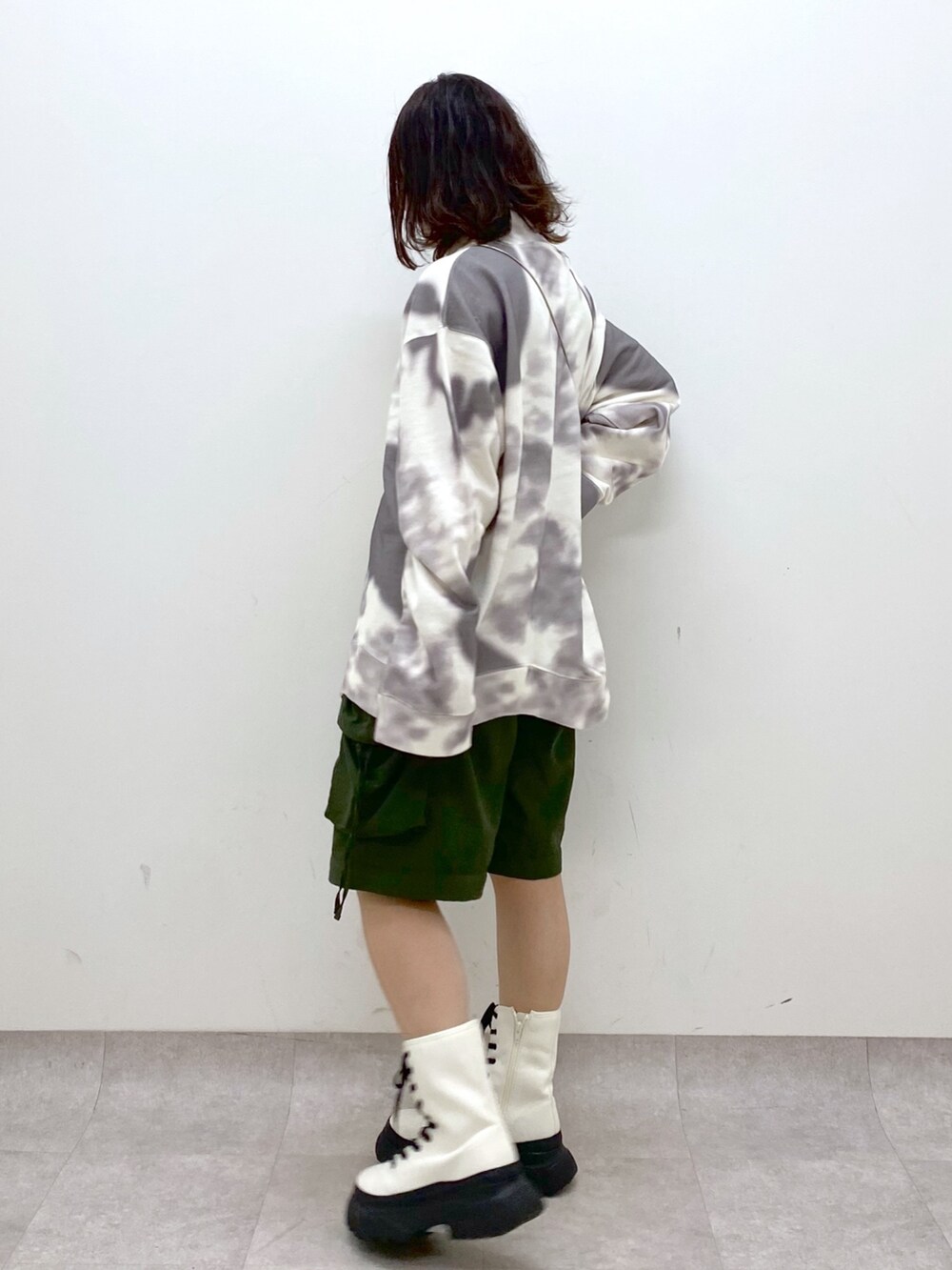 グリーン系のカーゴパンツ、ホワイト系のブーツ、ゴールド系のショルダーバッグを着用したレディースの冬コーディネートの6枚目の写真