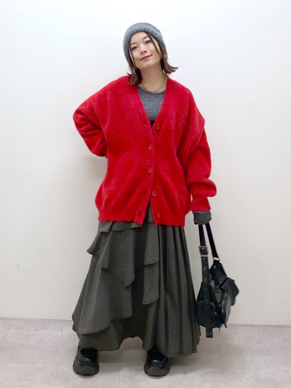 レッド系のカーディガン/ボレロ、シルバー系のTシャツ/カットソー、ブラウン系のスカートを着用したレディースの秋コーディネートの9枚目の写真