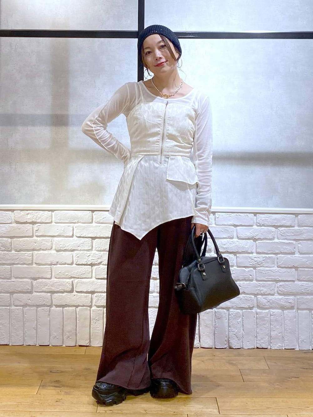 ブラック系のスニーカー、ブラック系のショルダーバッグ、ブラウン系のスウェットパンツを着用したレディースの秋コーディネートの4枚目の写真