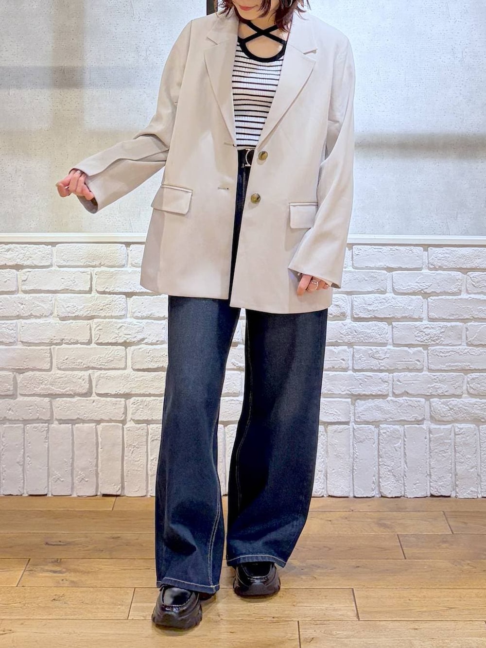 ブラック系のローファー、ブルー系のスラックス、ブラウン系のボストンバッグを着用したレディースの冬コーディネートの3枚目の写真