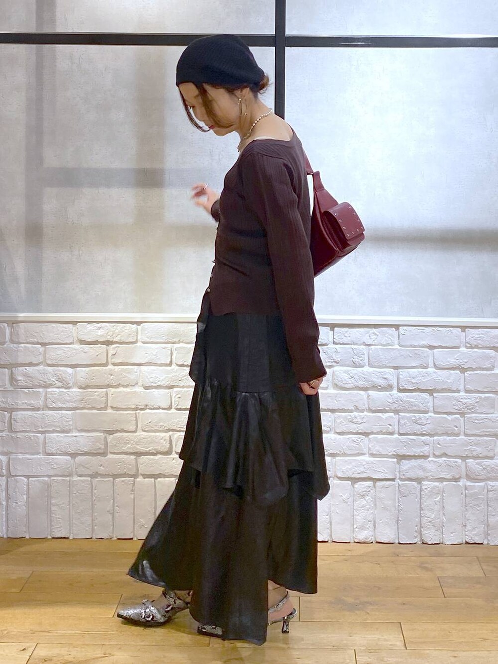 ホワイト系のパンプス、レッド系のショルダーバッグ、ブラック系のスカートを着用したレディースの夏コーディネートの5枚目の写真