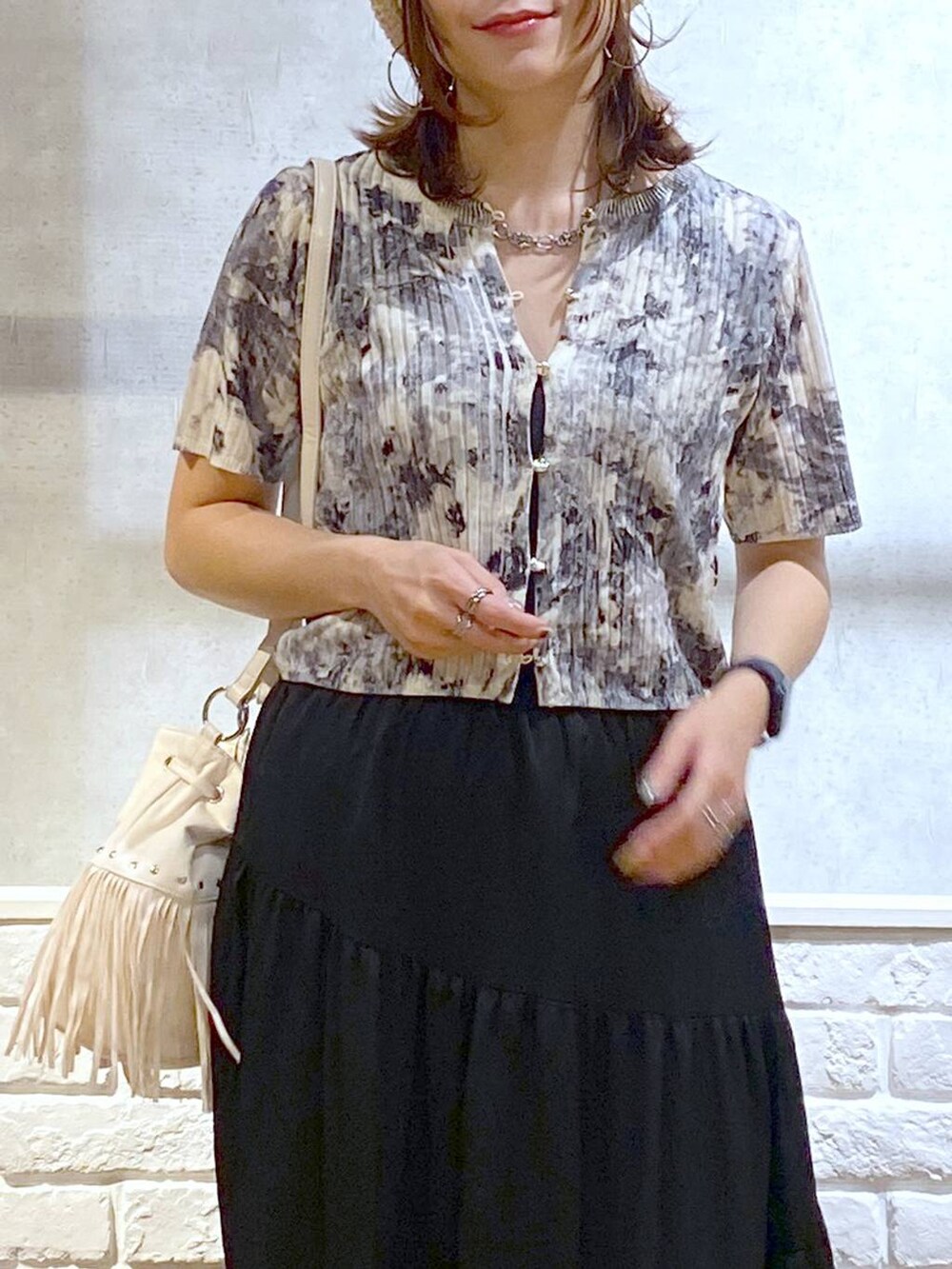 ブラック系のパンプス、ブラック系のスカート、ホワイト系のショルダーバッグを着用したレディースの夏コーディネートの2枚目の写真