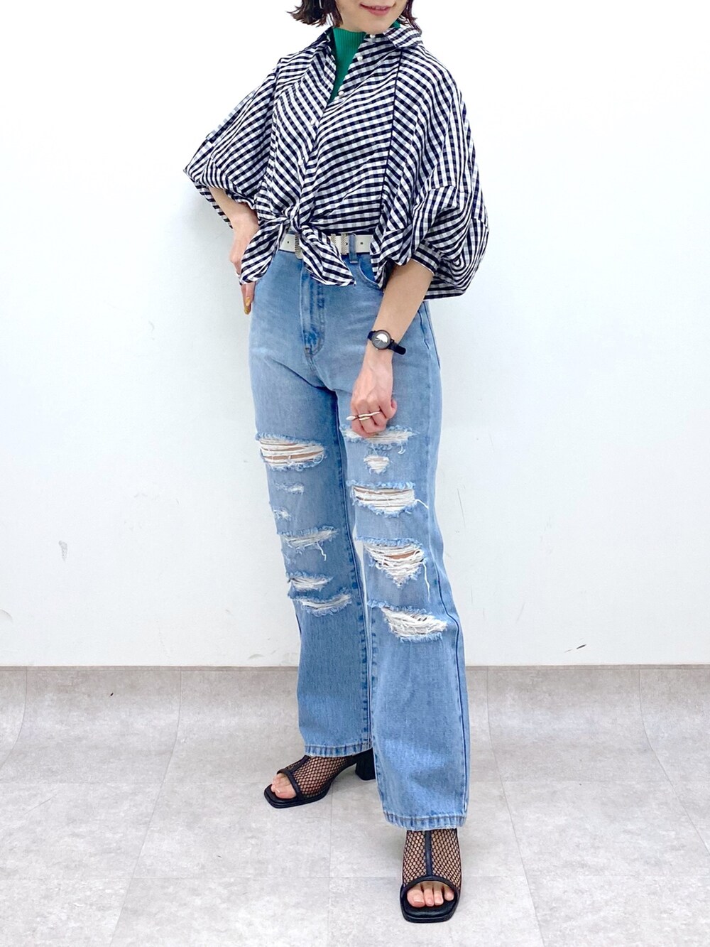 ブルー系のパンツ、ブラック系のシューズ、グリーン系のトップスを着用したレディースの春コーディネートの5枚目の写真