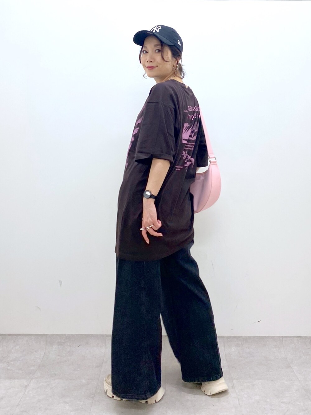 ピンク系のショルダーバッグ、ブラウン系のTシャツ/カットソー、ブラック系のデニムパンツを着用したレディースの夏コーディネートの5枚目の写真