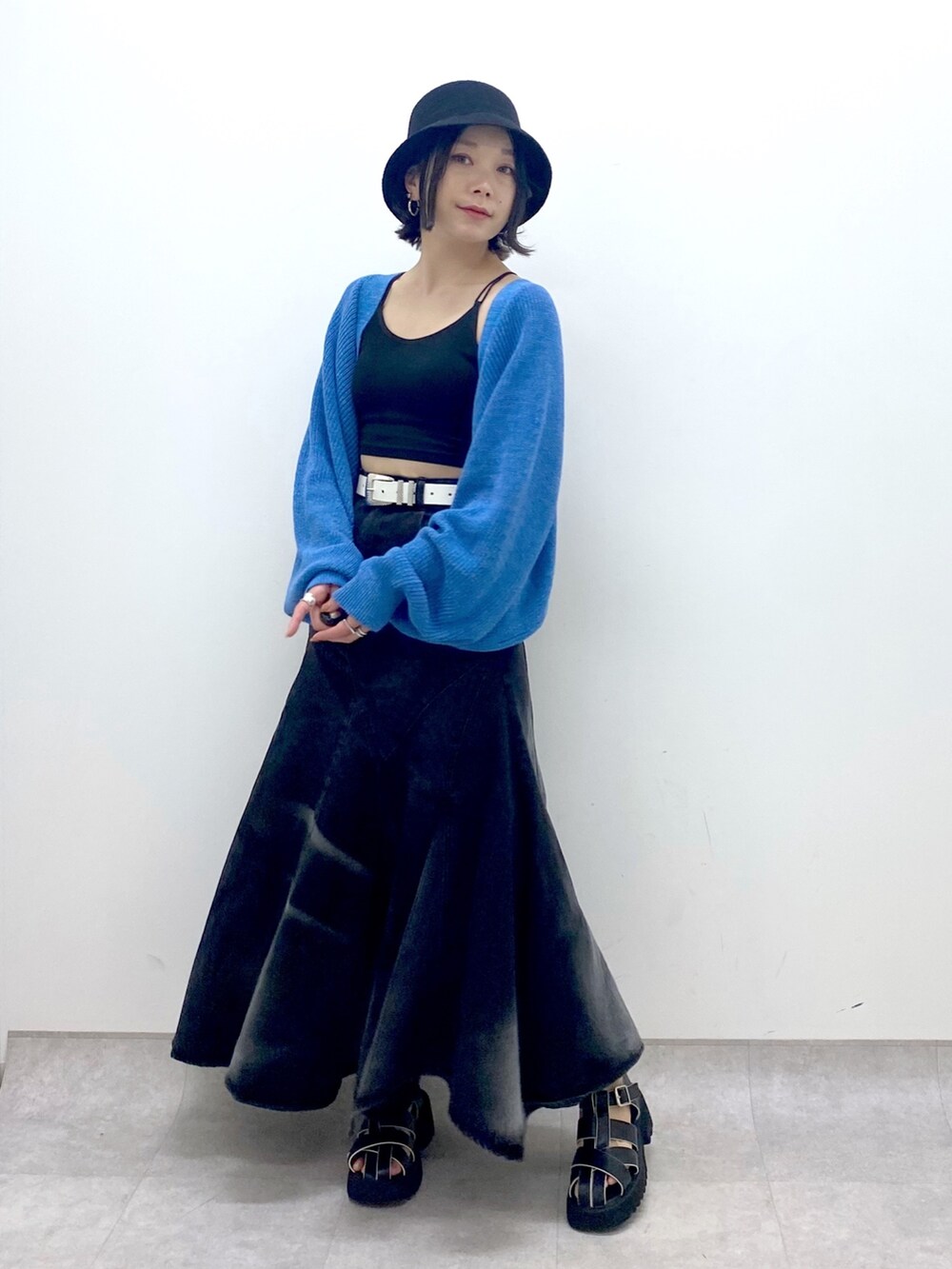 ブラック系のスカート、ブルー系のトップス、ブラック系のサンダルを着用したレディースの春コーディネートの5枚目の写真