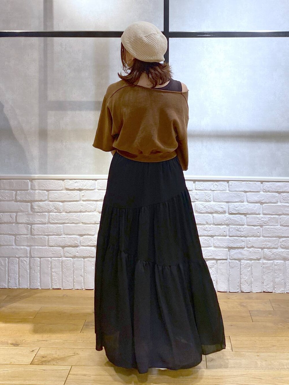 ブラウン系のタンクトップ、ブラック系のショルダーバッグ、ホワイト系のスニーカーを着用したレディースの夏コーディネートの6枚目の写真