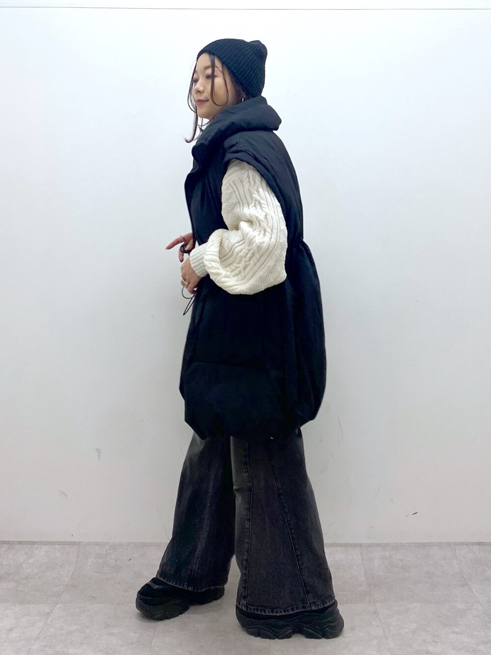 ブラック系のブルゾン、ホワイト系のニット/セーター、ブラック系のデニムパンツを着用したレディースの冬コーディネートの6枚目の写真