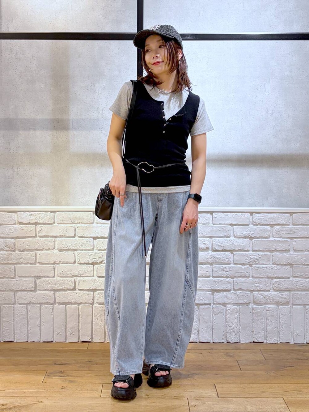 ブルー系のデニムパンツ、ブラック系のショルダーバッグ、ブラック系のサンダルを着用したレディースの春コーディネートの9枚目の写真