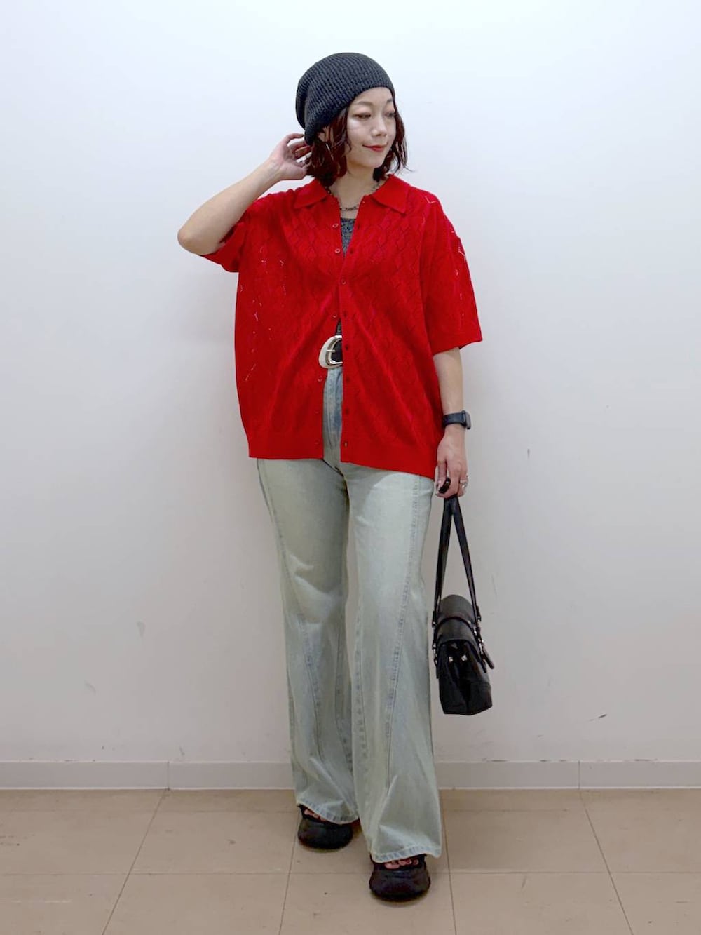 レッド系のポロシャツ、ブルー系のデニムパンツ、ブラック系のサンダルを着用したレディースの夏コーディネートの8枚目の写真